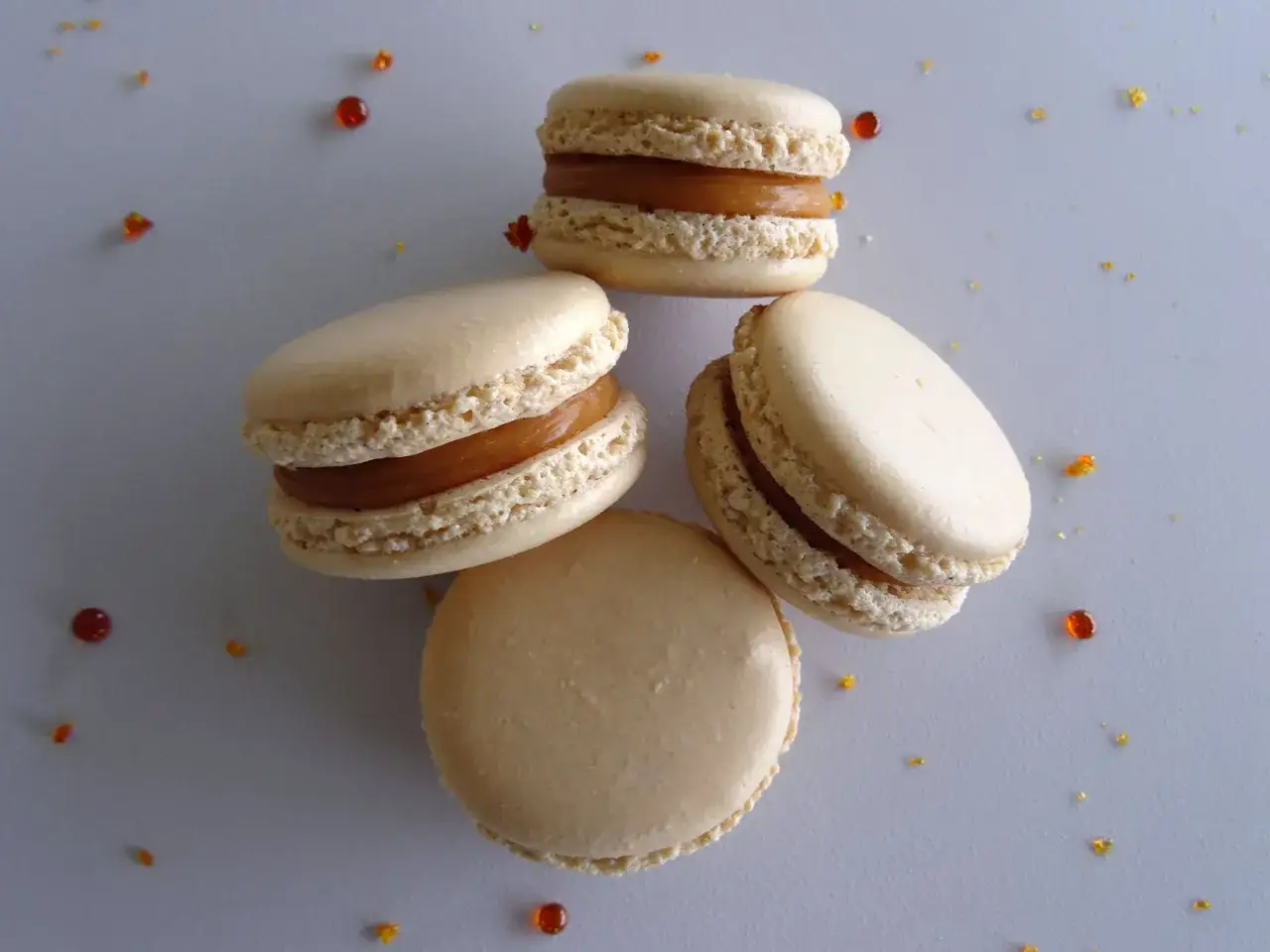 Quatre macarons au caramel beurre sal&eacute;, parsem&eacute;s de quelques &eacute;clats de caramel ambr&eacute;.