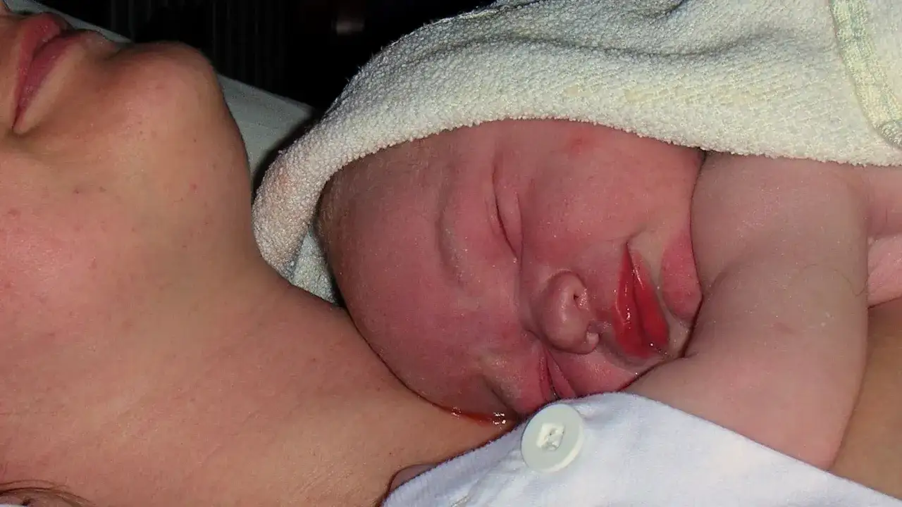 Nyf&ouml;dd bebis vilar mot sin mammas hud. Hud mot hud-kontakt f&ouml;r v&auml;rme och trygghet.