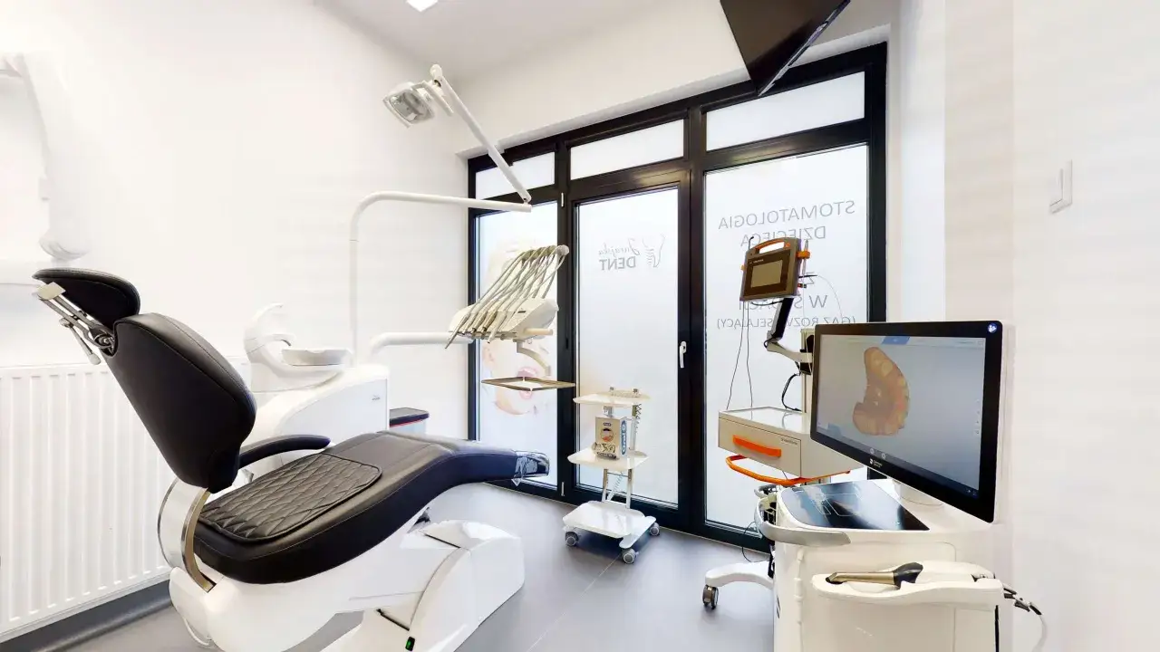 Nowoczesny gabinet stomatologiczny z fotelem dentystycznym i sprzętem.