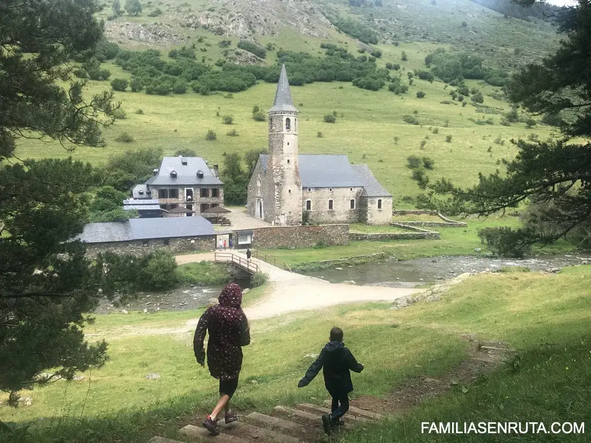 Niños exploran un pueblo pirenaico con iglesia y río. ¡Ideal para saber qué hacer en Vielha con niños!