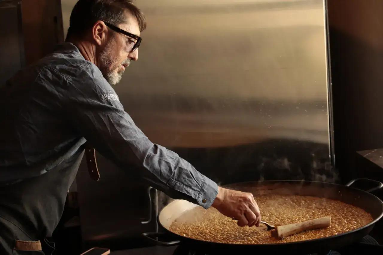 Chef prepara paella, buscando la solución perfecta para el arroz duro.