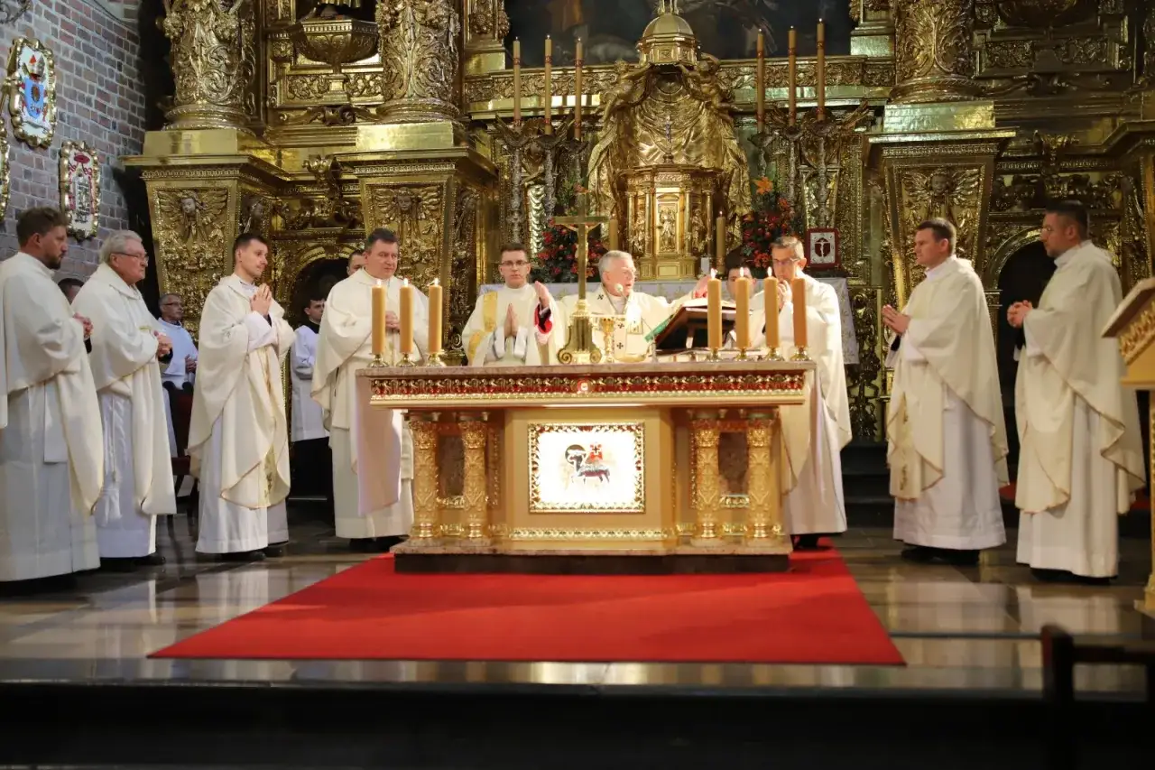 Uroczysta msza święta z udziałem duchownych w bogato zdobionej kaplicy. Centralnym punktem jest ołtarz, przy którym odbywa się konsekracja.