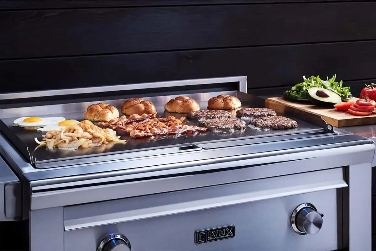 Des hamburgers, bacon, &oelig;ufs et oignons cuisent sur une plancha gaz. Apprenez comment allumer plancha gaz pour un repas parfait.