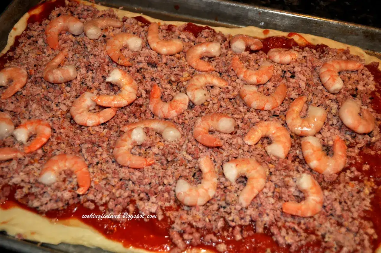 Pizza med r&auml;kor och skinka, redo att bakas. En h&auml;rlig kombination av smaker som v&auml;ntar p&aring; att avnjutas.