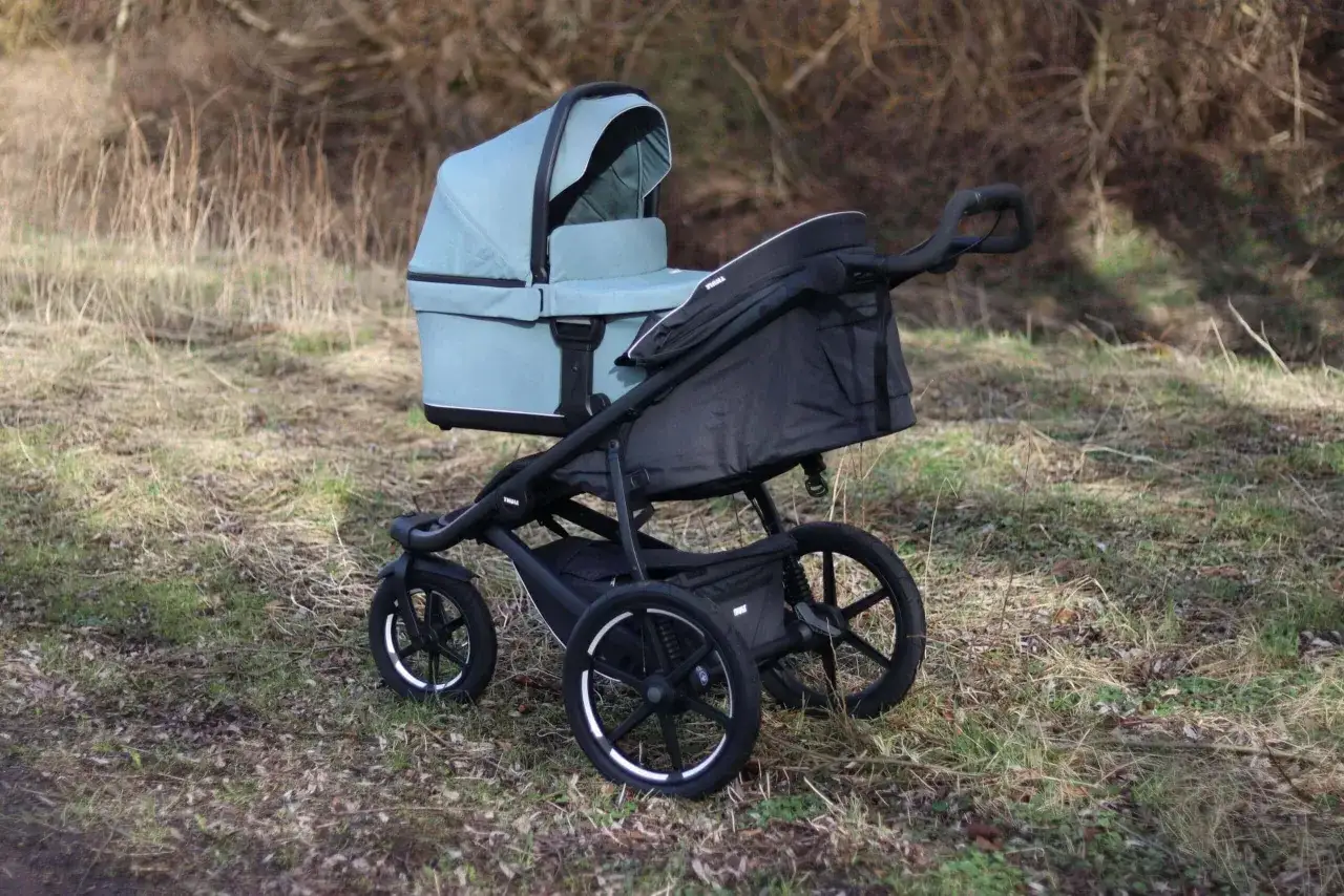En ljusblå Thule Urban Glide liggdel på ett svart chassi, redo för äventyr i naturen.