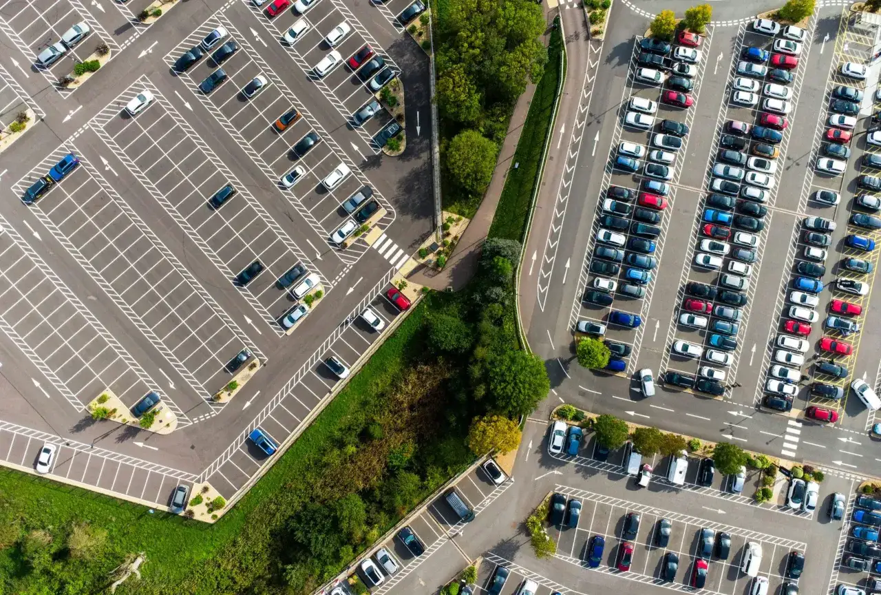 Duży parking lotniskowy z wieloma samochodami. Zastanawiasz się, ile kosztuje parking na lotnisku Chopina?