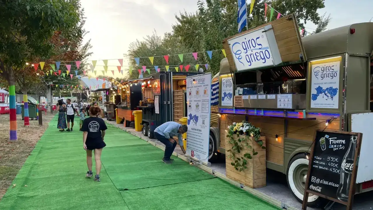 Paseo por un festival de ebro food trucks con luces y banderas. Un camión de
