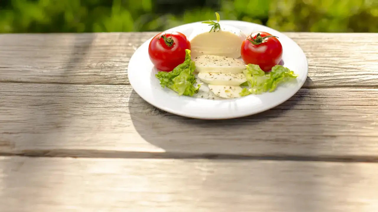 Piatto con pomodori, lattuga e fior di latte, un classico che, se consumato in eccesso, fa ingrassare.