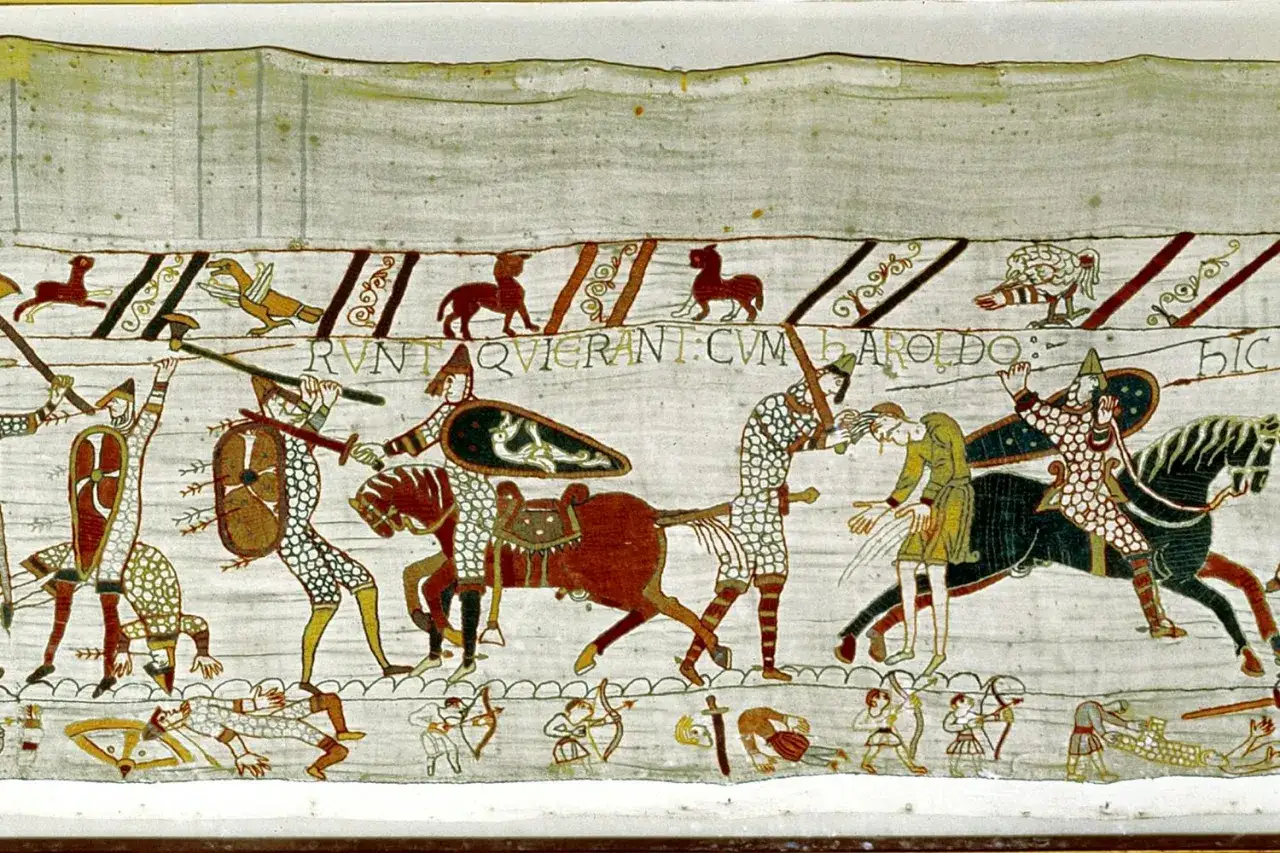 Scen fr&aring;n slaget vid Hastings 1066: soldater i ringbrynjor, h&auml;star och fallna krigare. Texten 