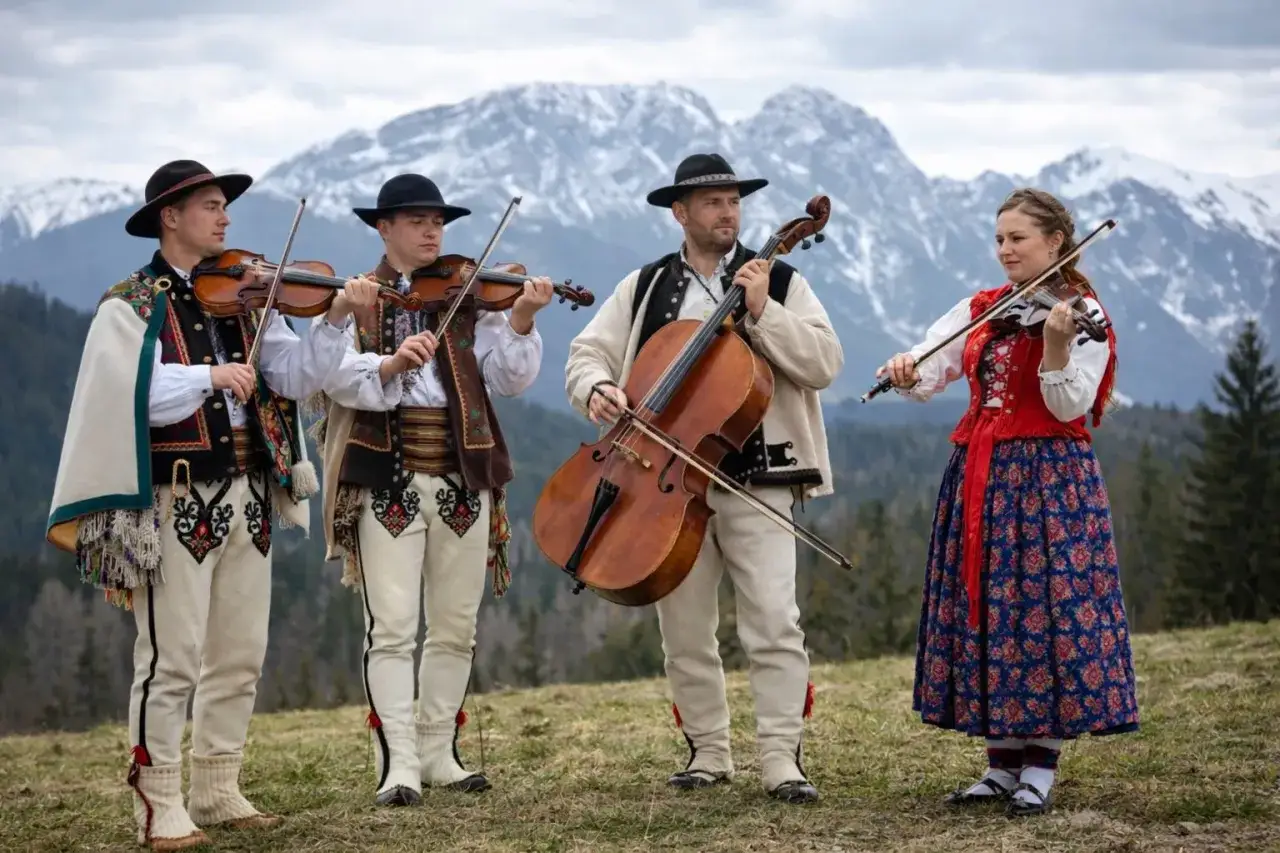 Muzykanci w strojach góralskich grają na instrumentach, prezentując żywą kulturę podhala.