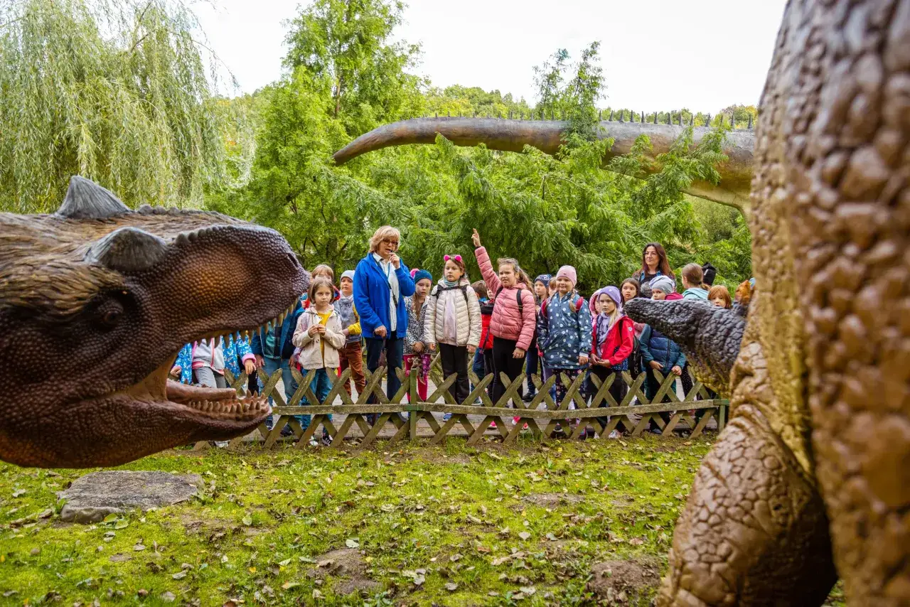 Dzieci z opiekunem zwiedzają park dinozaurów. Czy kierownik wycieczki może być opiekunem? Tak, gdy opowiada o prehistorii!