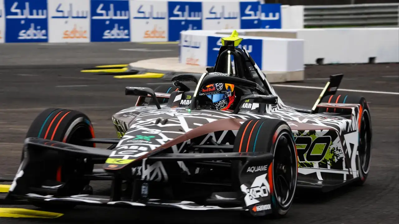 Coche de F&oacute;rmula E en Jarama, con dise&ntilde;o agresivo y colores vibrantes, compitiendo en la pista.