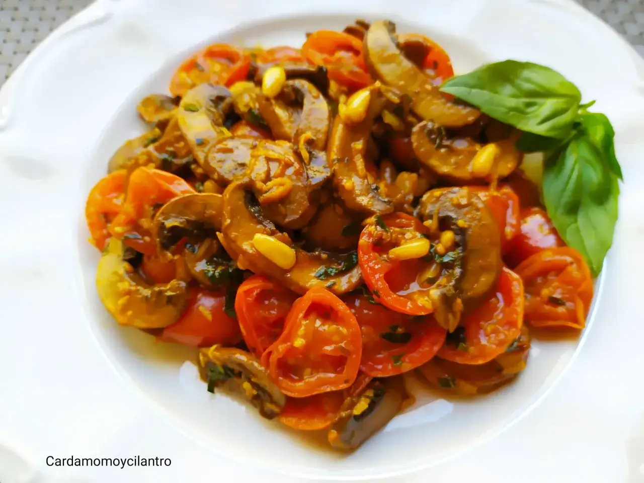 Plato de champi&ntilde;ones salteados con tomates cherry y albahaca. Una deliciosa opci&oacute;n para tus recetas con champi&ntilde;ones.