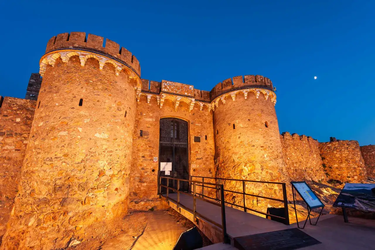 Imponente entrada a uno de los castillos de la Comunidad Valenciana, iluminado al anochecer.