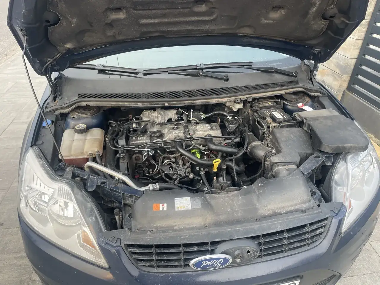 Silnik Ford Focus 1.8 TDCI z otwartą maską. Widoczny akumulator, płyny i elementy układu paliwowego.