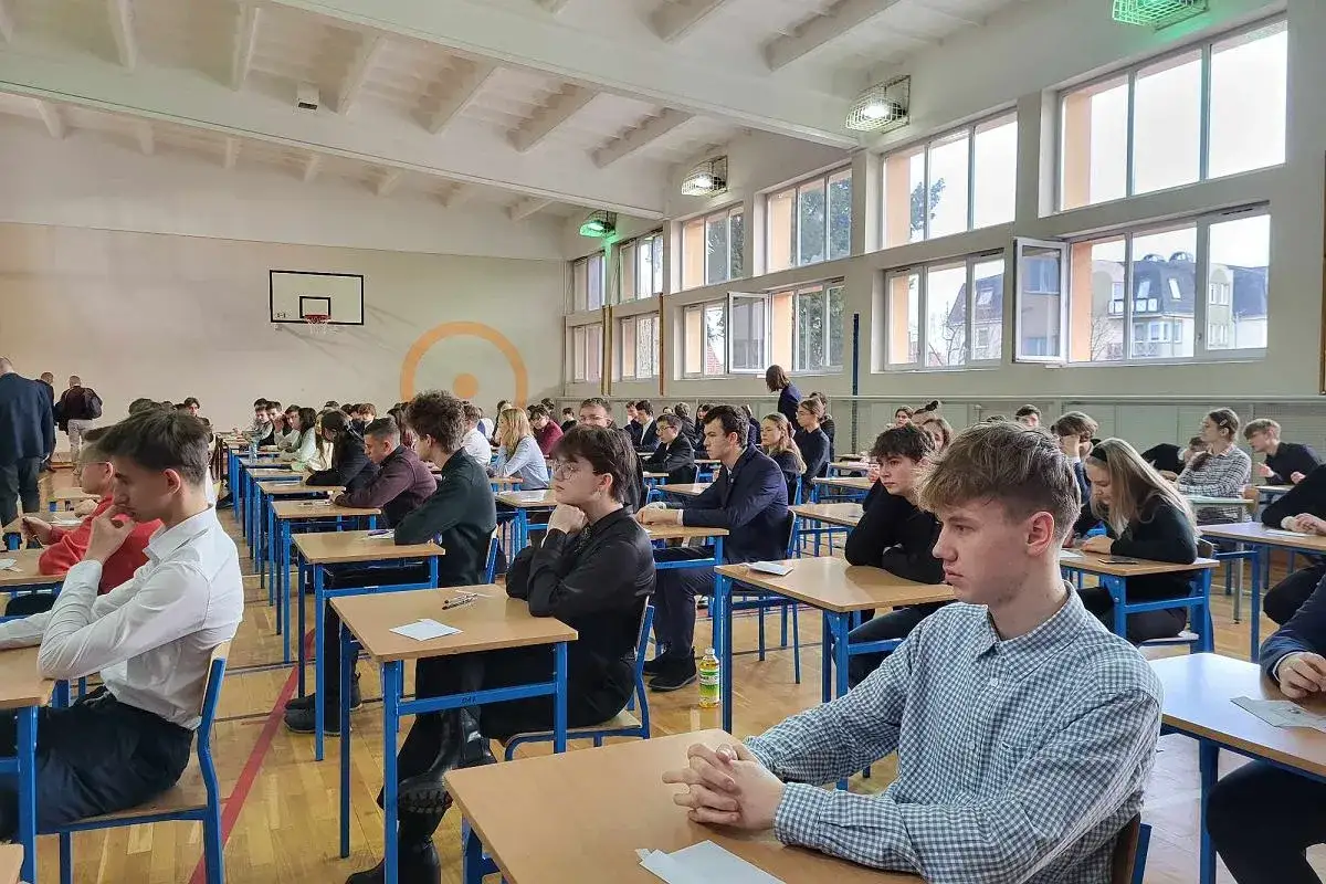 Uczniowie siedzą w ławkach podczas egzaminu. Po rozszerzonej geografii można robić wiele rzeczy, np. studiować turystykę, kartografię czy geologię.