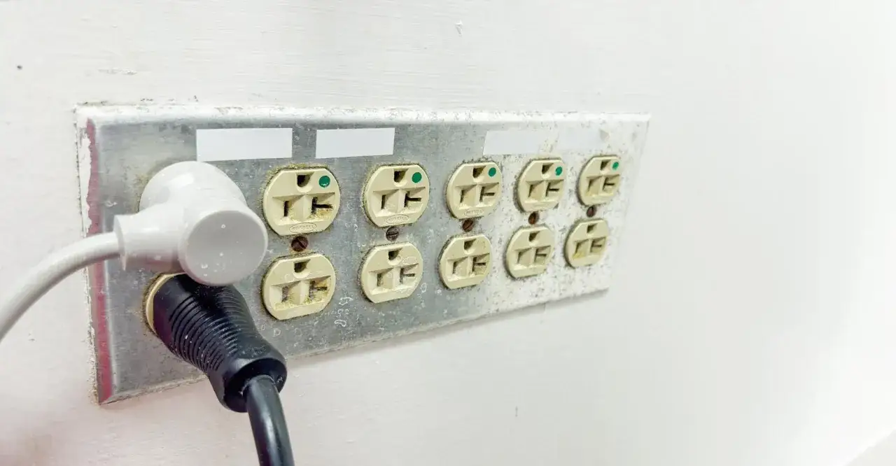 Zabezpieczenie gniazdka elektrycznego: wtyczki wpięte w listwę z wieloma gniazdami, chroniąc przed przypadkowym dotknięciem.