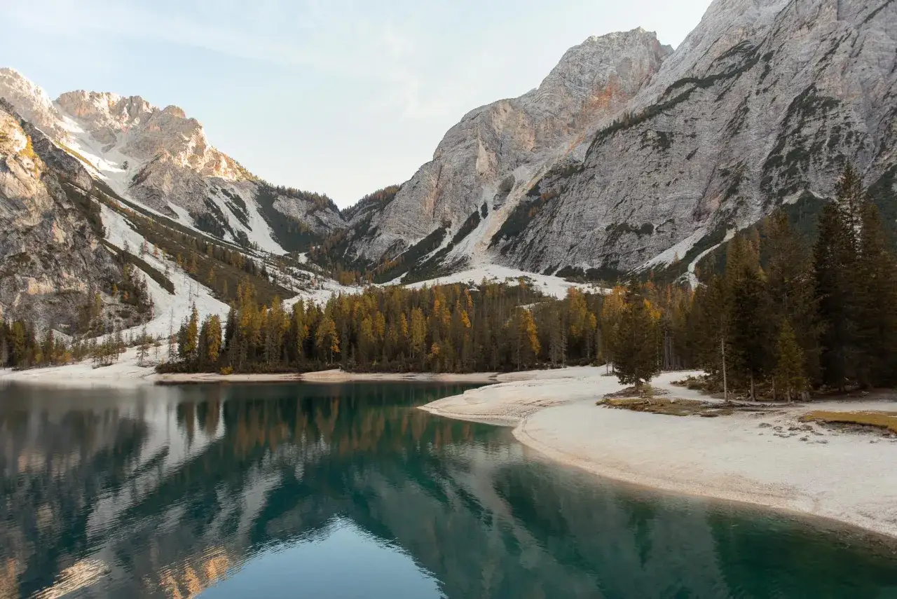 Spokojne jezioro odbija jesienne drzewa i skaliste szczyty. Włochy Dolomity zachwycają o tej porze roku.