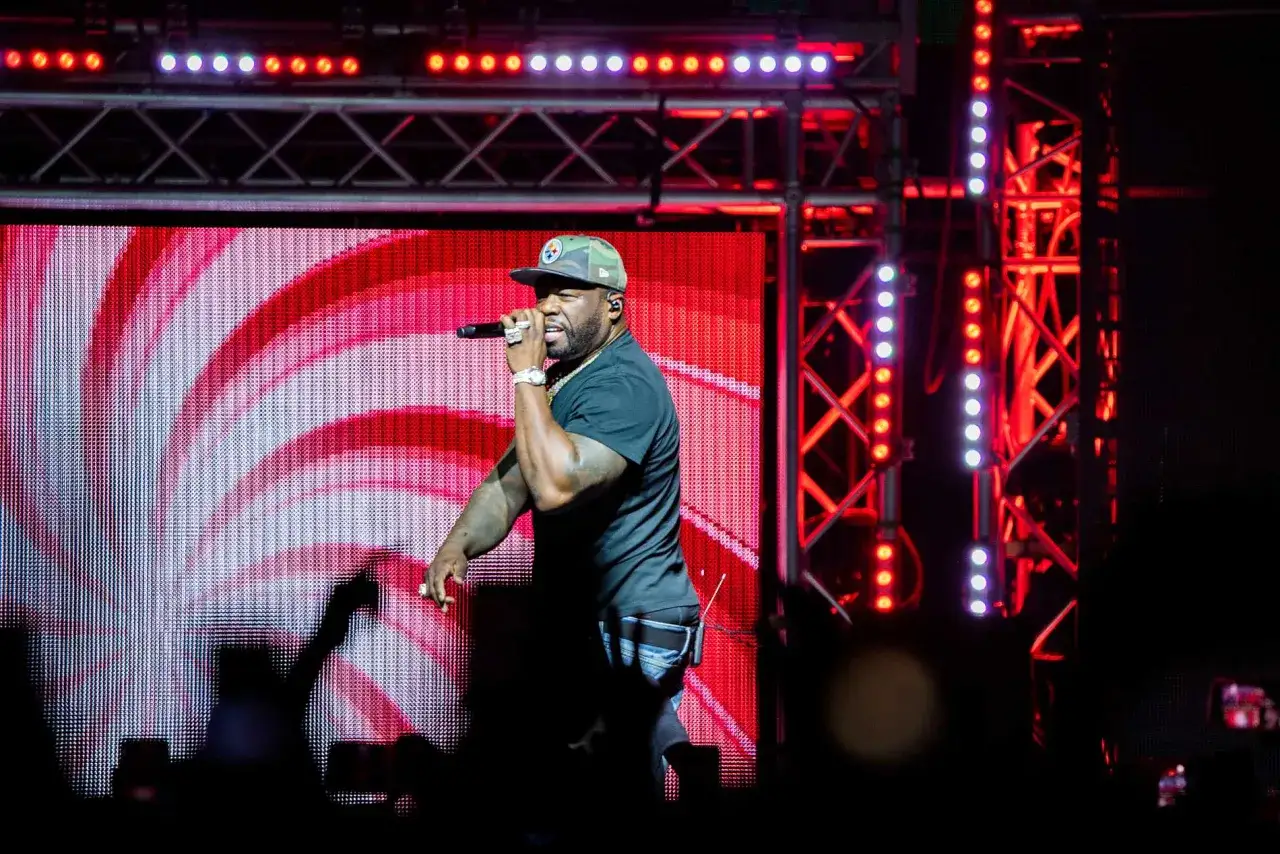 50 Cent p&aring; scen i Stockholm, med en r&ouml;dvit bakgrund och ljusshow.