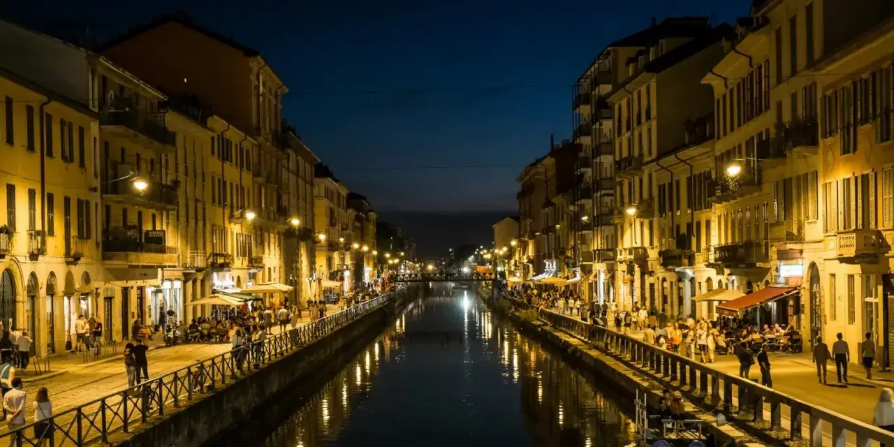Navigli di Milano di notte, con gente seduta ai tavolini dei locali, perfetti per trovare **cheap bars in Milan**.