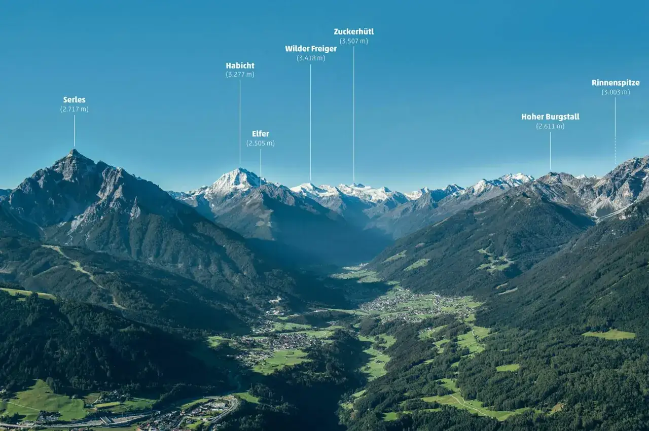 Majest&auml;tische Alpen mit dem Wilder Freiger im Zentrum. Ein Tal mit D&ouml;rfern und W&auml;ldern erstreckt sich unter schneebedeckten Gipfeln.