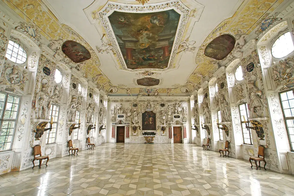 Prunkvoller Festsaal in einem Schloss im Bodenseekreis. Deckenmalerei, Stuck und Skulpturen schmücken den Raum.