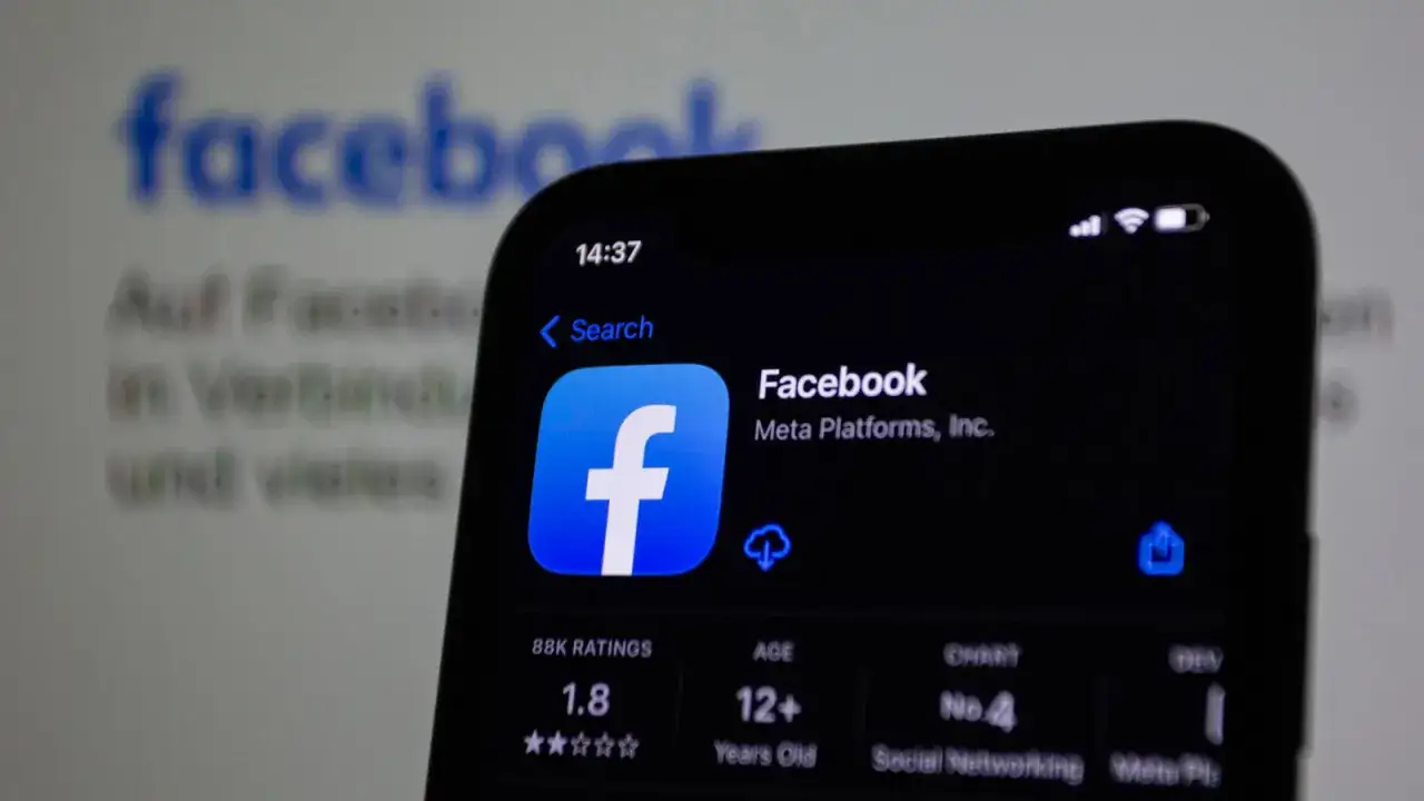 Ekran telefonu z aplikacją Facebook. W tle logo Facebooka, sugerujące zaczepki fb.