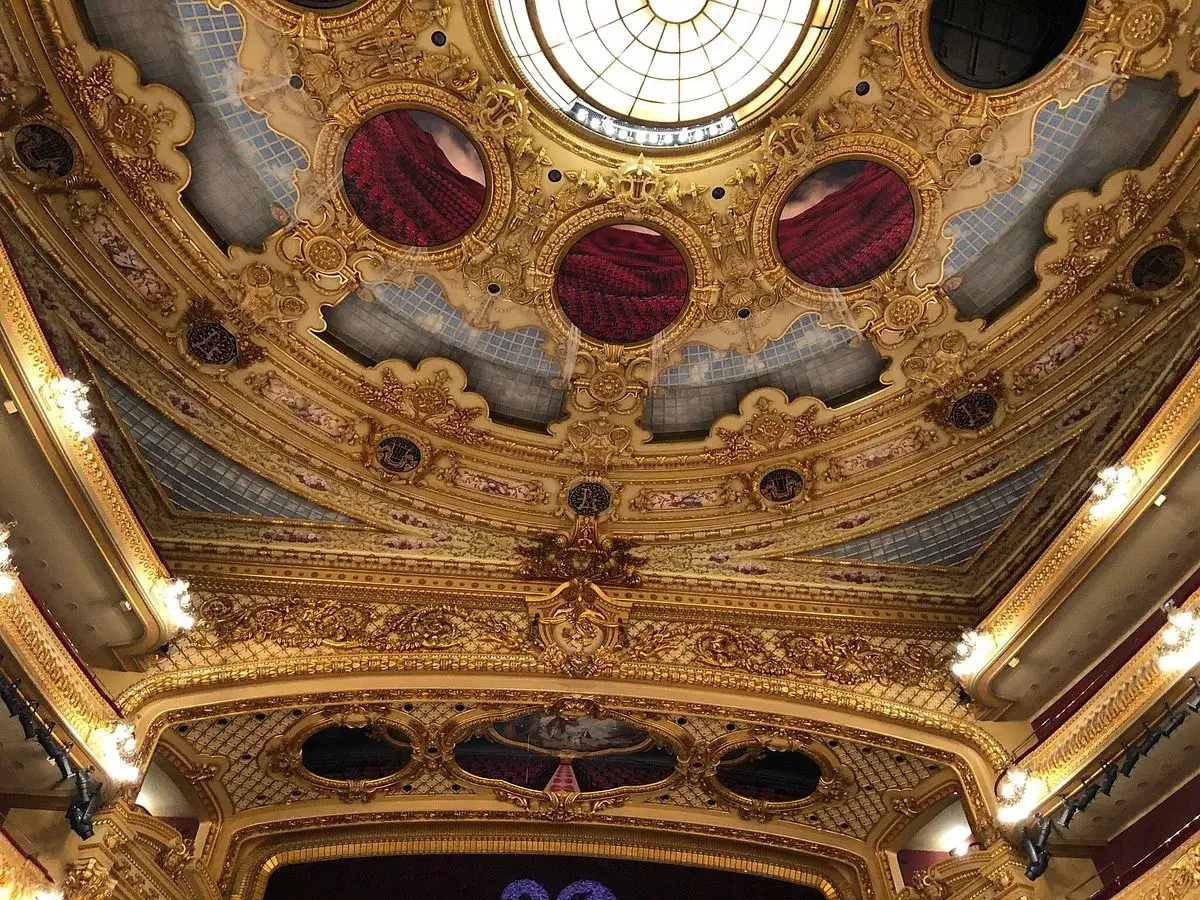 Prunkvolle Decke des Gran Teatre del Liceu mit goldenen Verzierungen, roten Vorh&auml;ngen und einem runden Oberlicht.