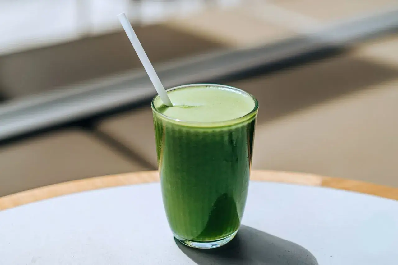 Ein Glas grüner Selleriesaft mit Strohhalm. Die positive selleriesaft wirkung ist bekannt für seine gesundheitlichen Vorteile.