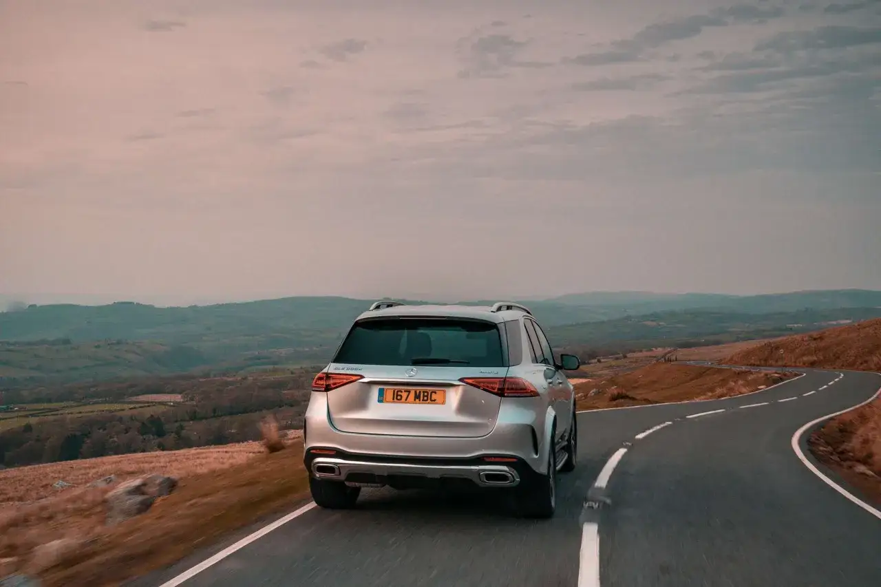 Srebrny Mercedes GLE 400d pokonuje kręty górski trakt.