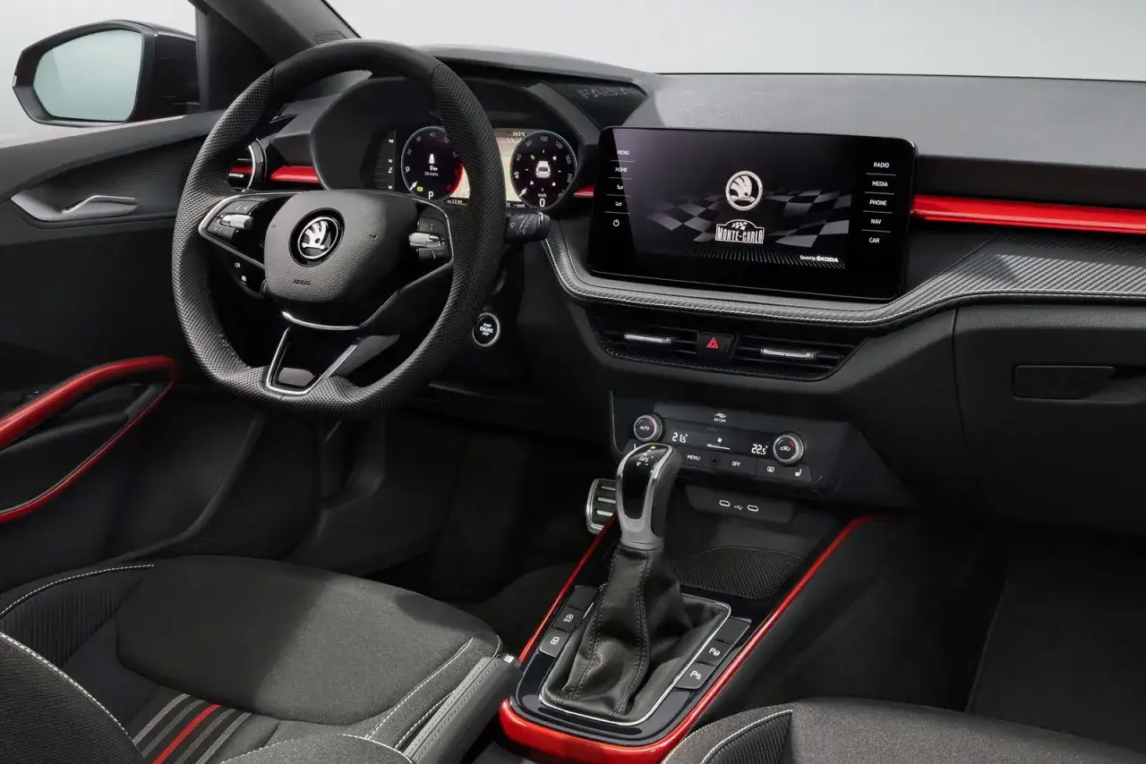Interni sportivi della Skoda Fabia Montecarlo: volante in pelle, display centrale con logo Monte Carlo, sedili con inserti rossi e finiture sportive.