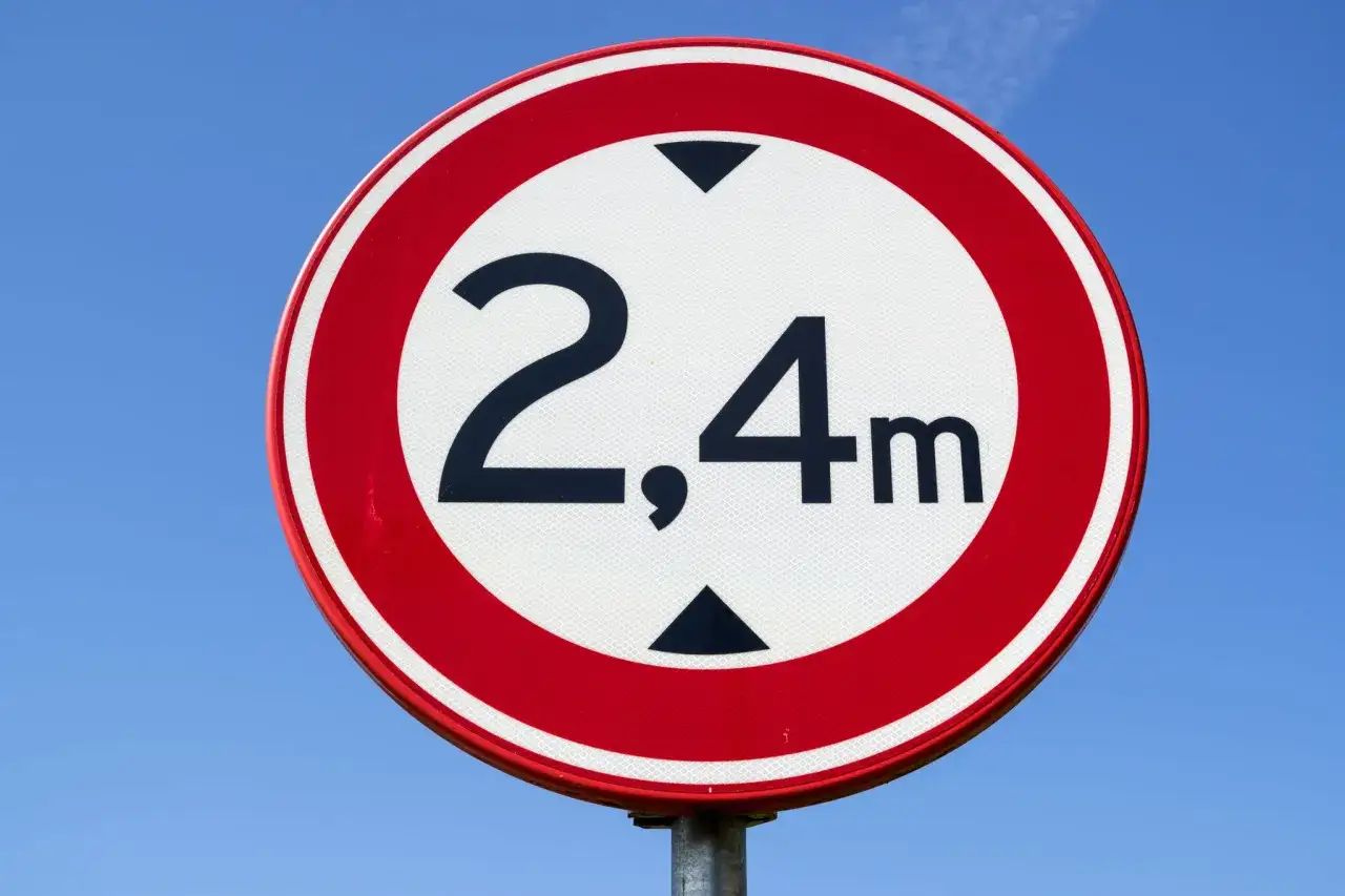 Znak ograniczenia wysokości 2,4m. Jaki mandat za jazdę ciężarówką w zakazie? Kierowca ciężarówki musi uważać na ten znak.