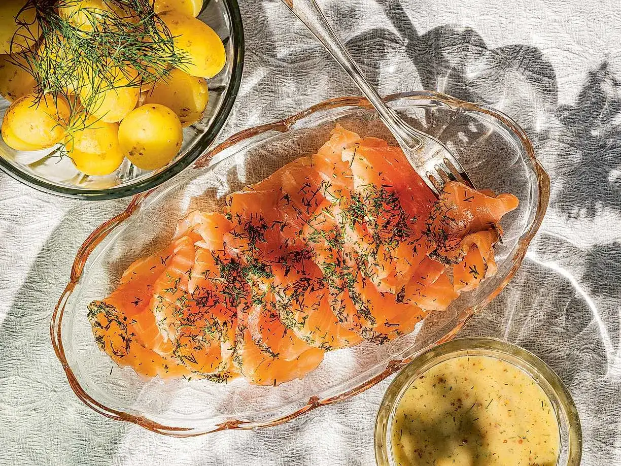 En skål med gravlax, dill och småpotatis. Bredvid en liten skål med gravlaxsås recept. Perfekt för en sommarbuffé.