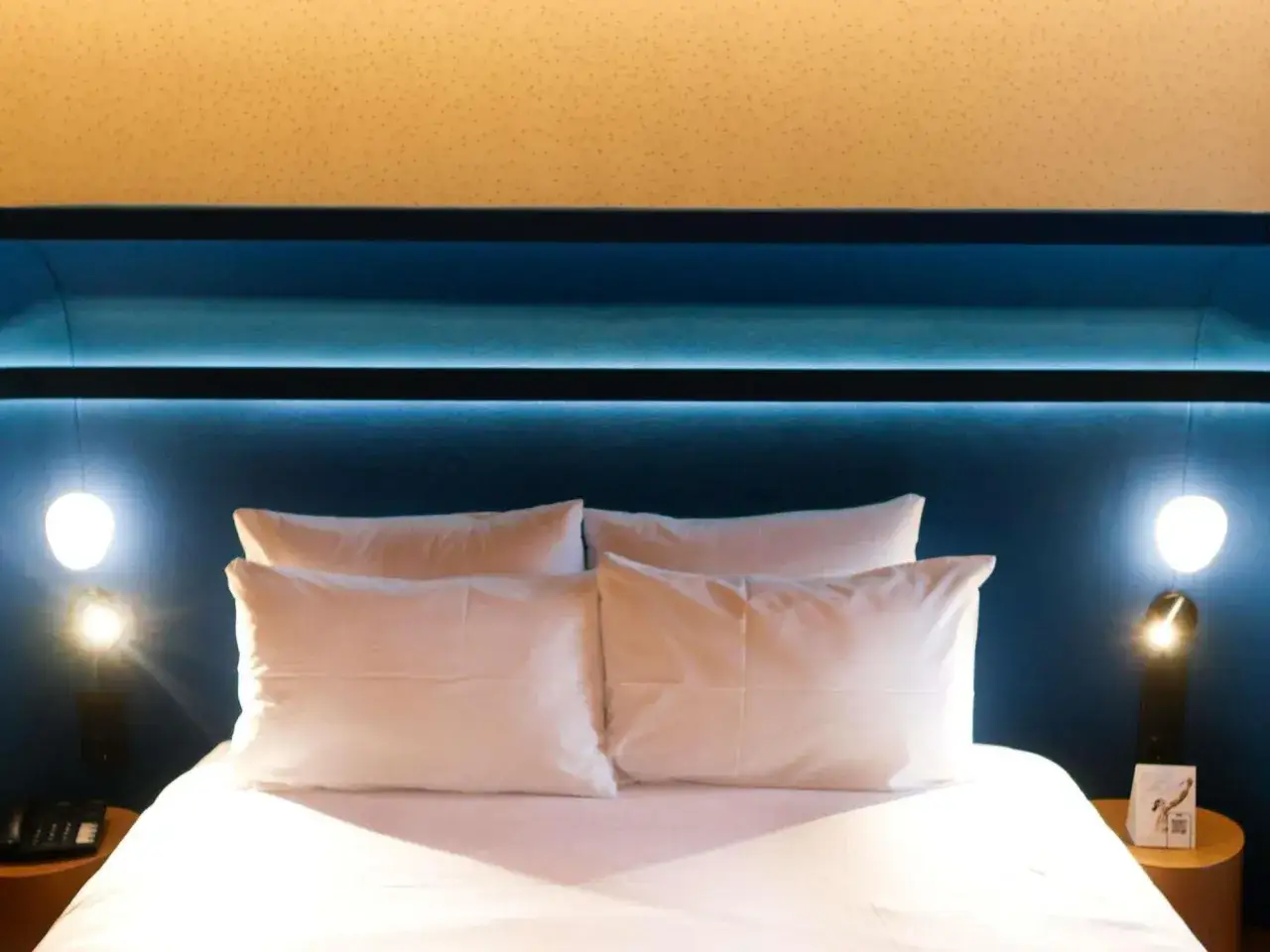 Wygodne łóżko z białymi poduszkami w pokoju hotelowym Mercure Warszawa Centrum.