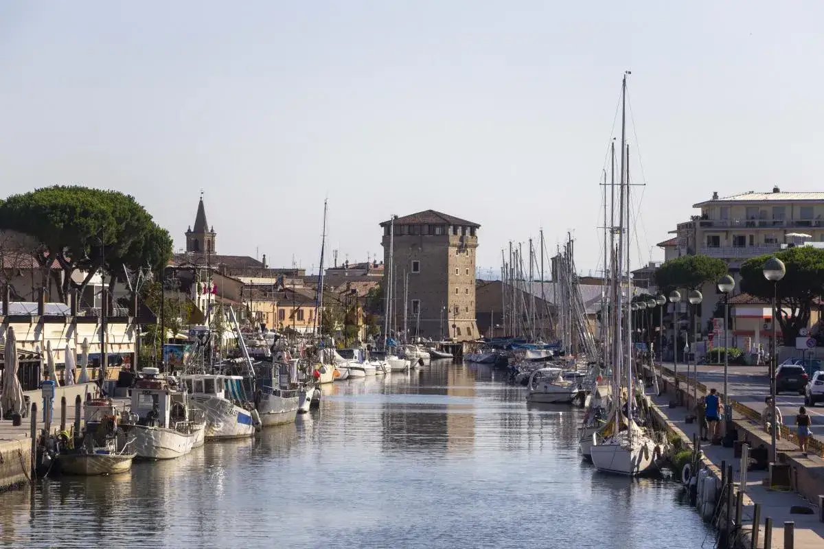 Porto Canale di Cervia con barche e la torre San Michele. Ottimo punto di partenza per scoprire cosa vedere vicino a Cervia.