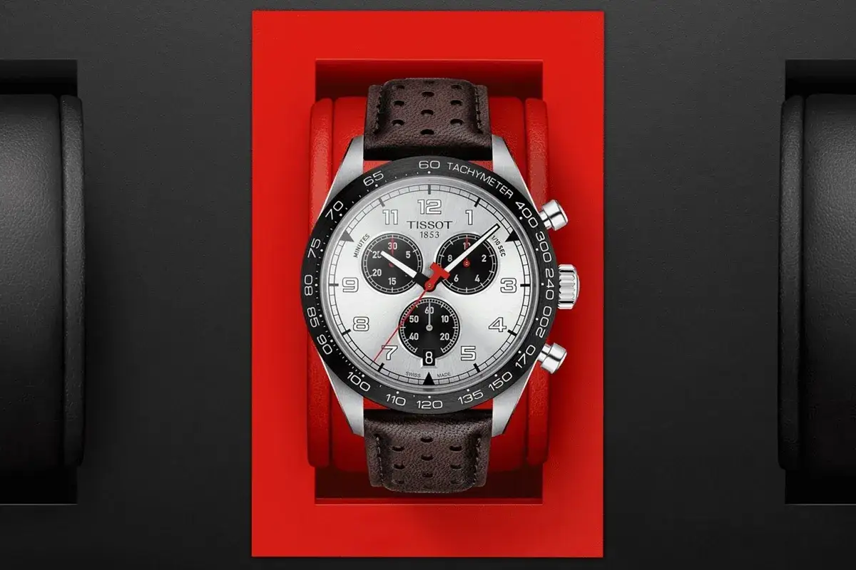 Zegarek Tissot z czarnym bezelem, na którym widnieje skala tachymetru. Skórzany pasek dodaje mu elegancji.