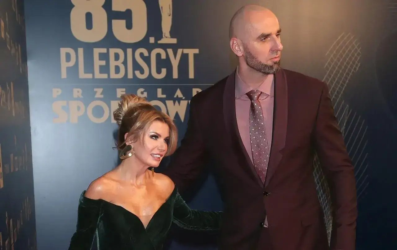 Marcin Gortat z żoną na gali. Elegancka para pozuje na tle napisu 