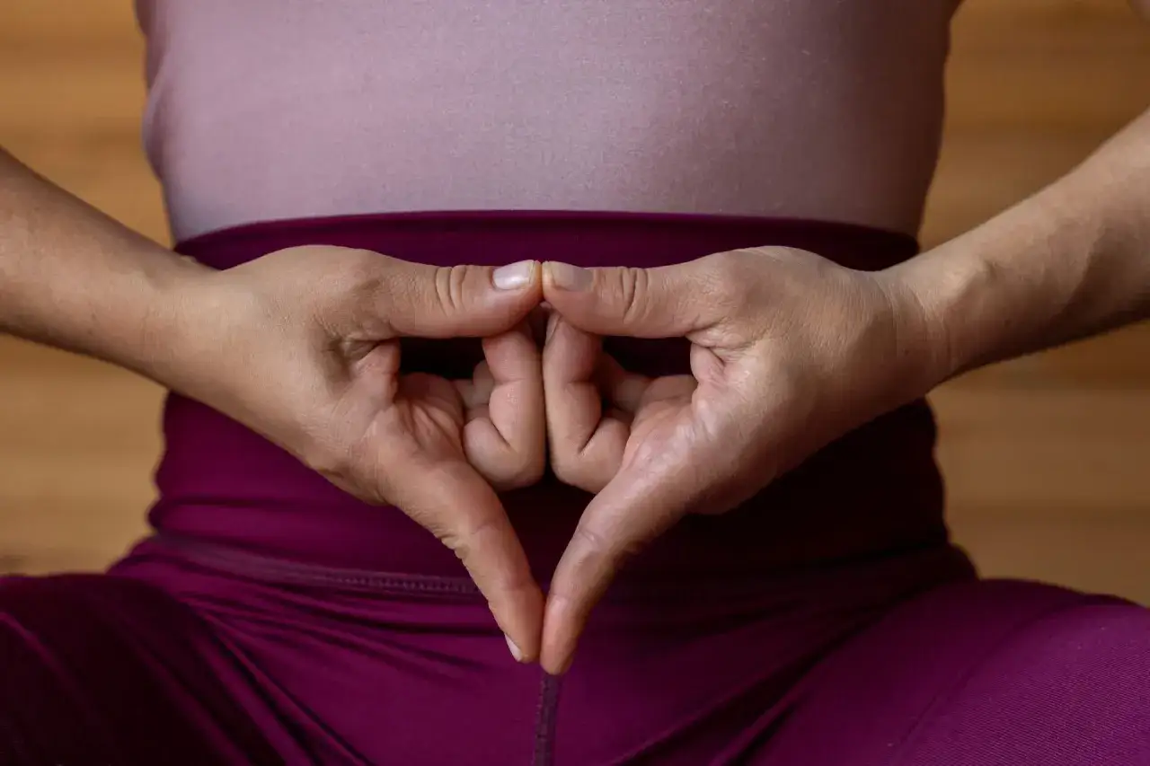 Manos formando el yoni mudra, símbolo de la energía femenina y la creación.