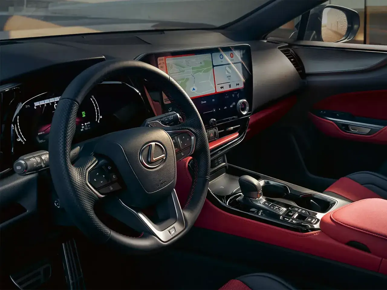 Interi&ouml;rbild fr&aring;n en Lexus NX 350h testk&ouml;rning. R&ouml;d och svart interi&ouml;r med stor peksk&auml;rm och digital instrumentpanel.