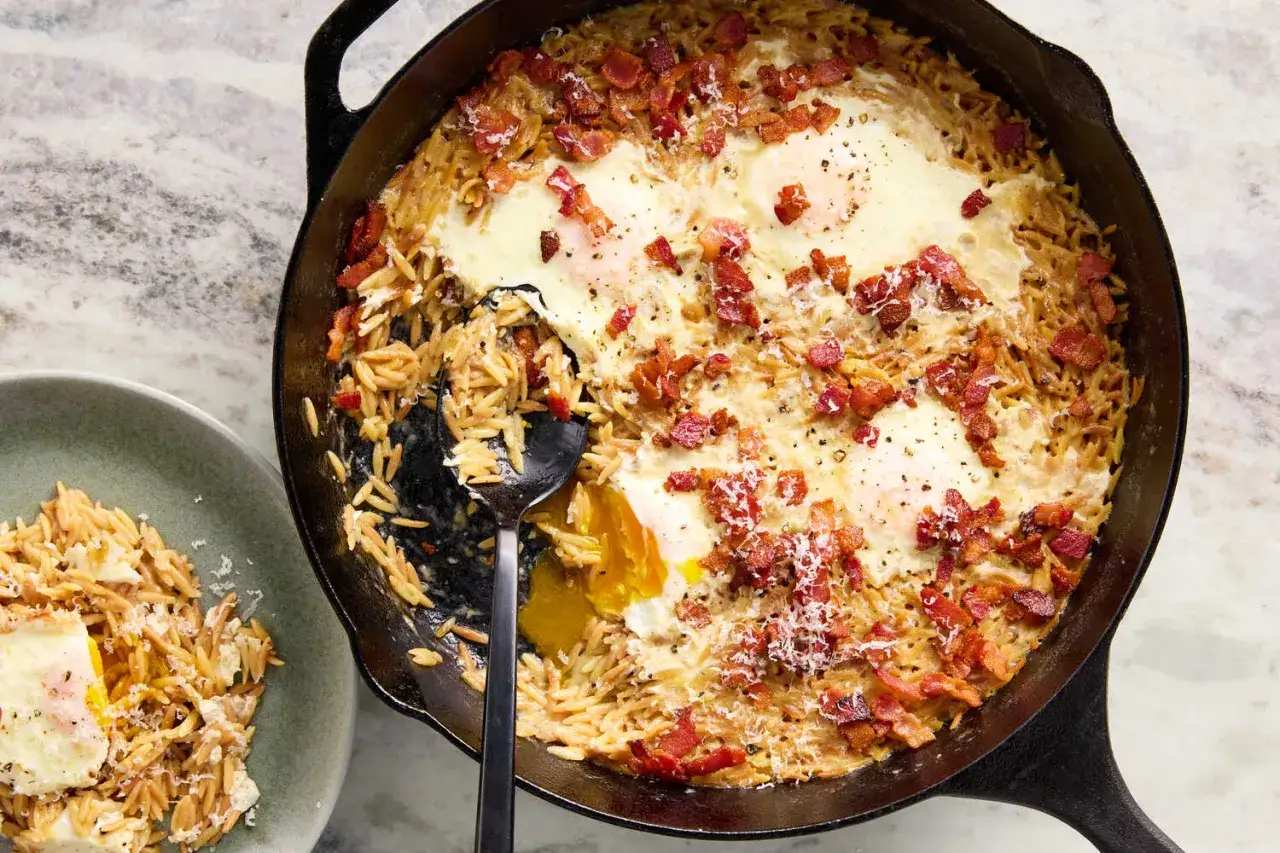 Szybki obiad z niczego: jajka zapiekane w makaronie orzo z boczkiem i parmezanem. Idealne na leniwe śniadanie lub kolację.