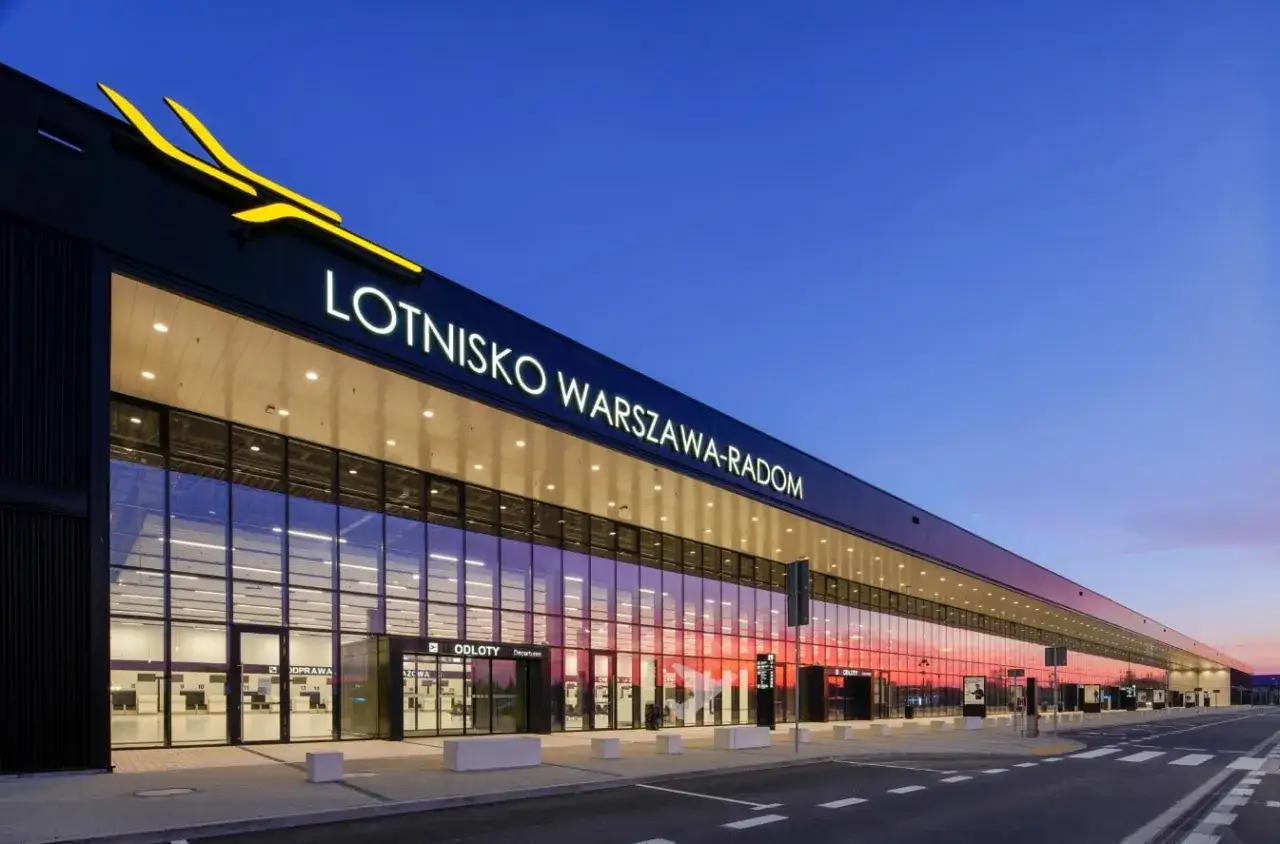 Nowoczesny budynek Lotniska Warszawa-Radom z napisem na fasadzie. Sprawdź lotnisko radom rozkład lotów i zaplanuj podróż.