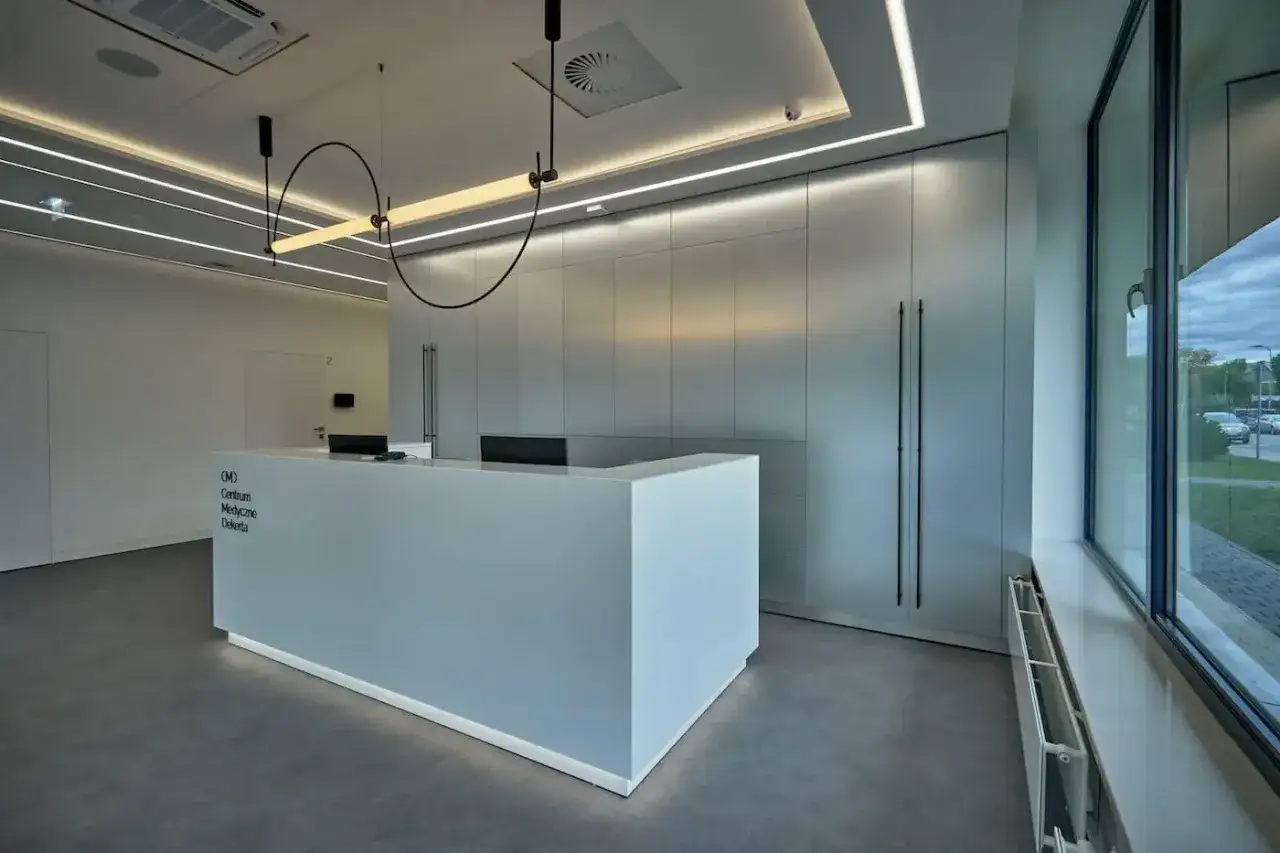 Nowoczesne centrum medyczne z recepcją i minimalistycznym wystrojem.