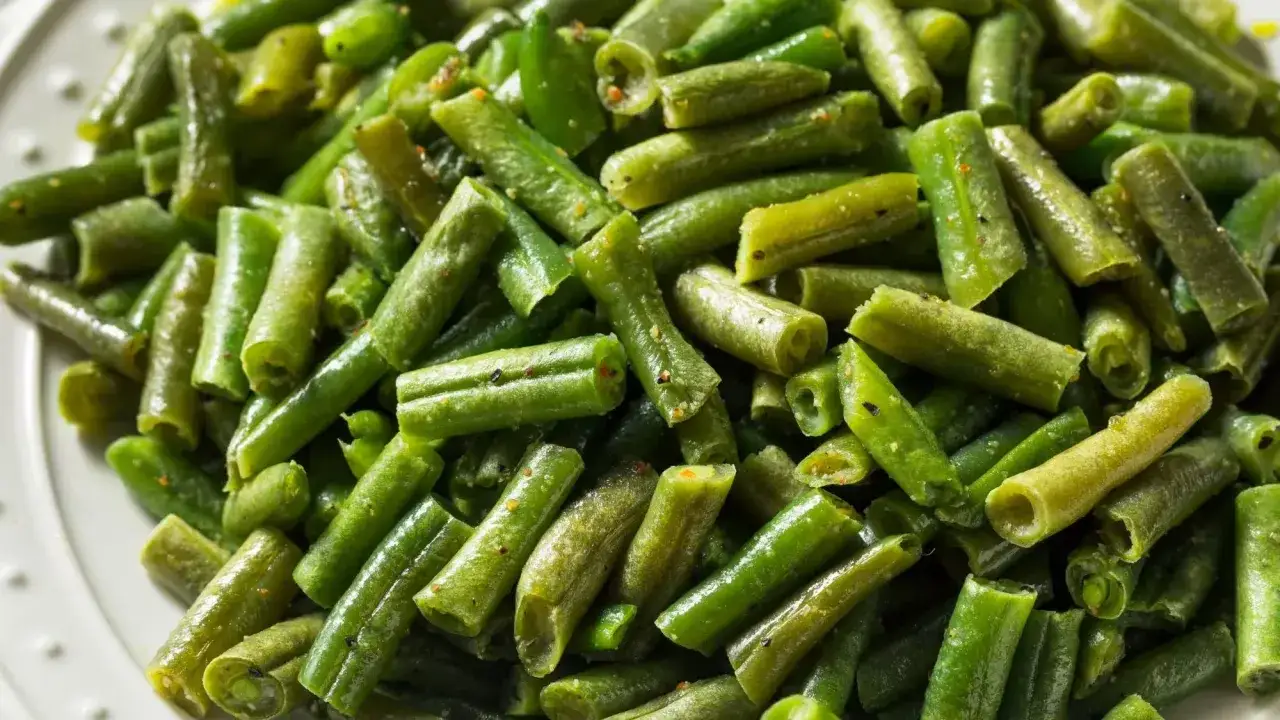 Une assiette de haricots verts coupés, assaisonnés et prêts à être dégustés. Parfait pour une recette haricot vert simple et rapide.