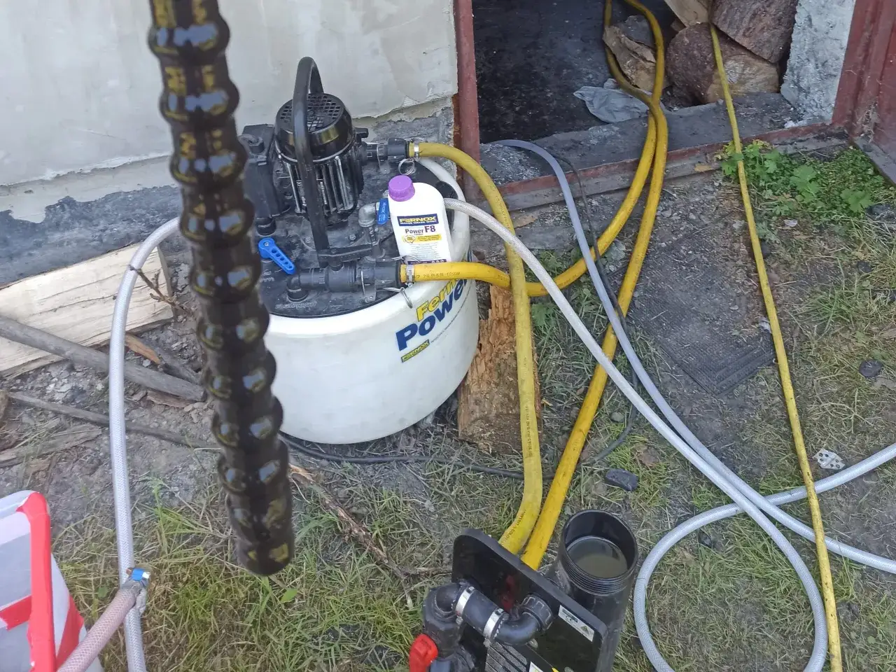 Urządzenie do płukania instalacji CO z płynem Fernox Power F8. Wąż doprowadzający i odprowadzający wodę.