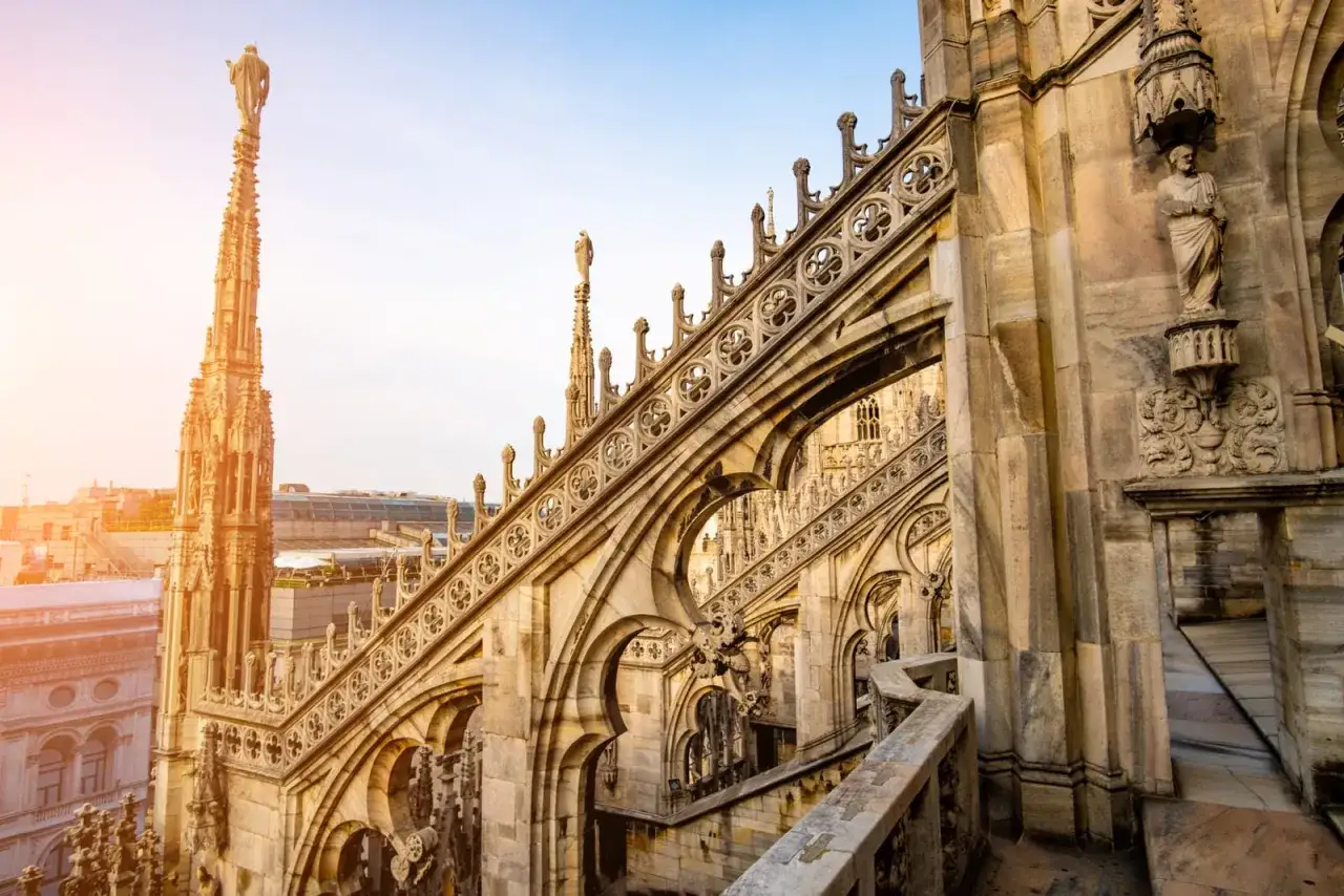 Kamienne detale i iglice katedry Duomo w Mediolanie w listopadzie, oświetlone łagodnym słońcem.