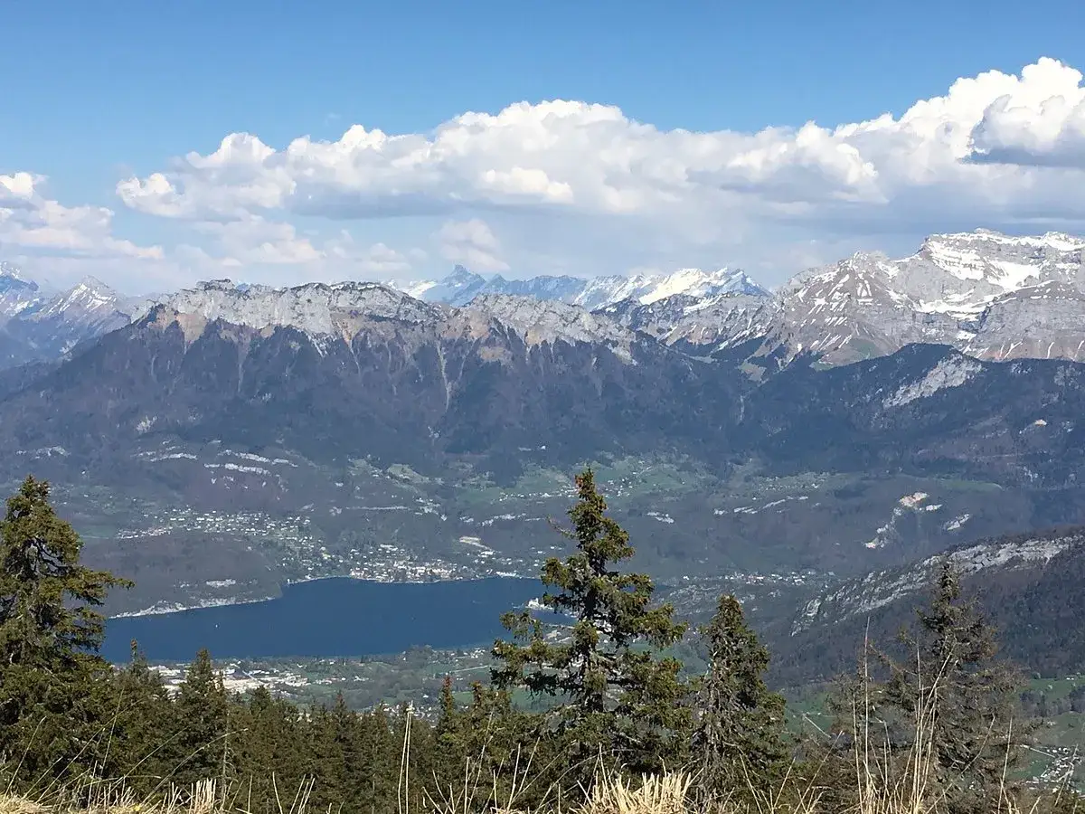 Vue panoramique sur le lac d'Annecy et les montagnes enneig&eacute;es. Id&eacute;al pour d&eacute;couvrir les choses &agrave; faire &agrave; Annecy.