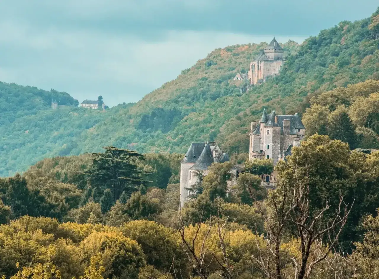 Châteaux médiévaux perchés sur des collines verdoyantes, un paysage enchanteur pour savoir que faire en Dordogne.