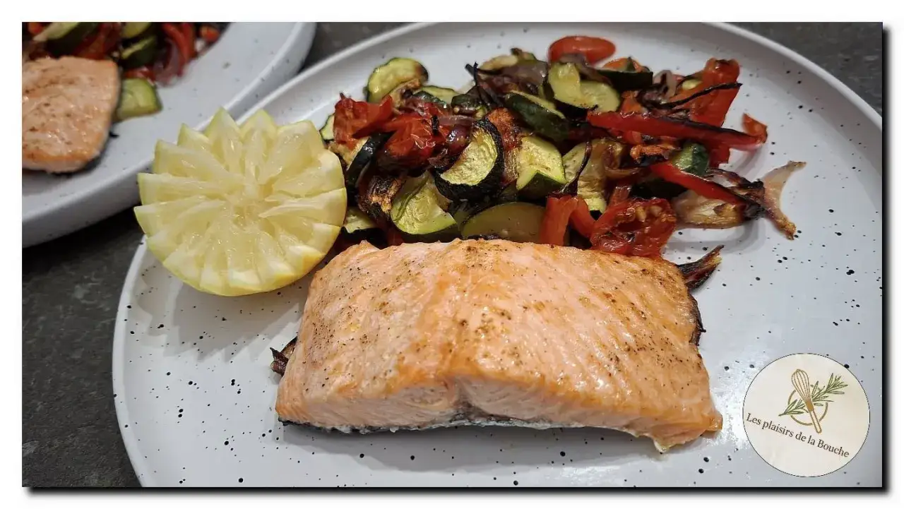 Pavé de saumon au four, accompagné de légumes rôtis et d'une tranche de citron sculptée. Un délice simple et sain.