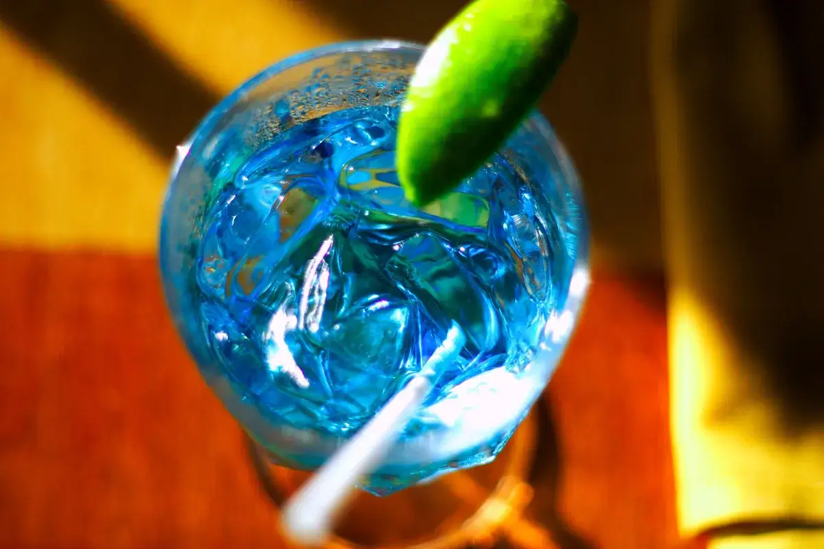 Niebieski gin z tonikiem i blue curacao, ozdobiony limonką, kusi orzeźwiającym smakiem.