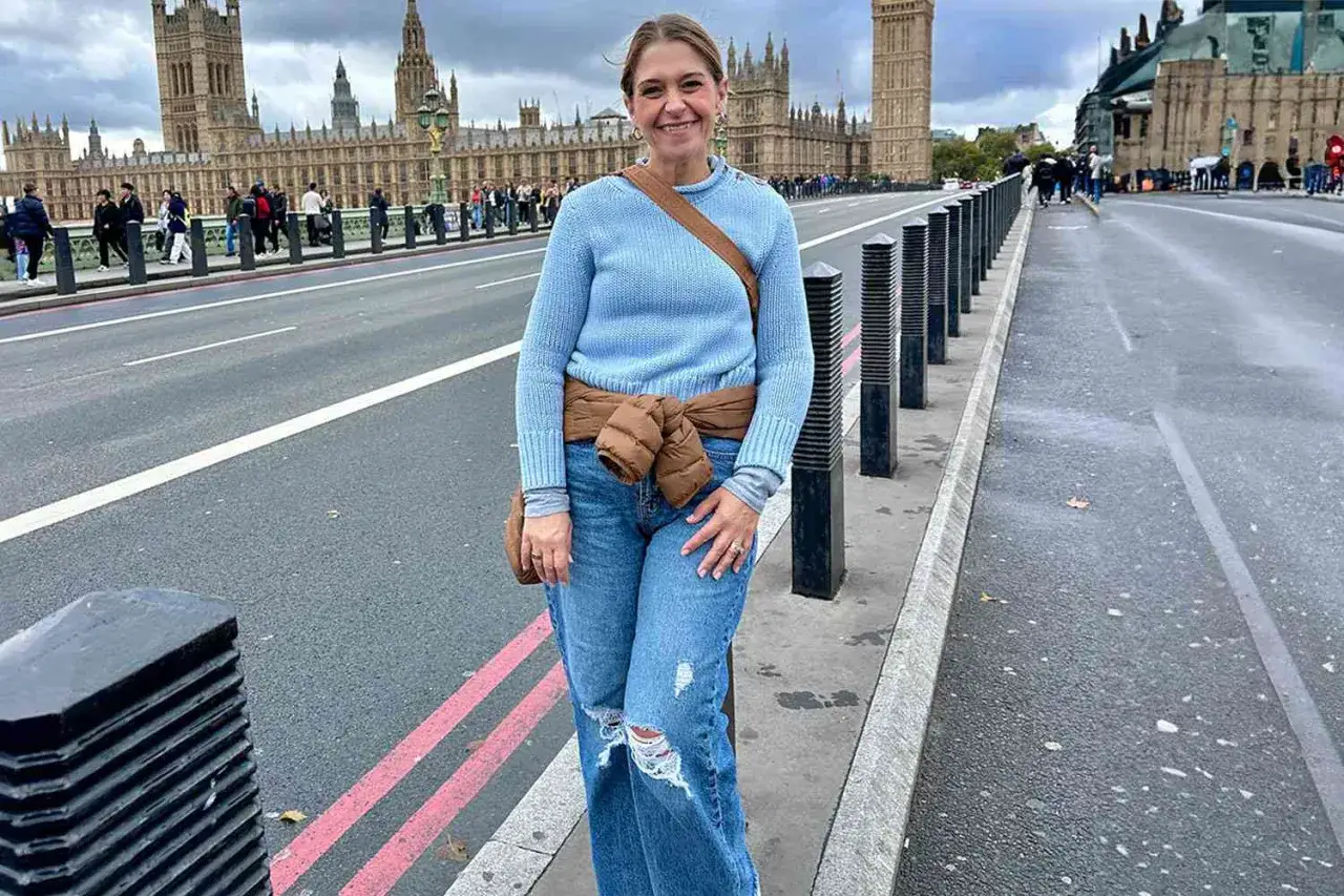 Kvinna i bl&aring; tr&ouml;ja och jeans poserar framf&ouml;r Houses of Parliament. Perfekt f&ouml;r en packlista London med bekv&auml;ma kl&auml;der f&ouml;r stadsvandring.